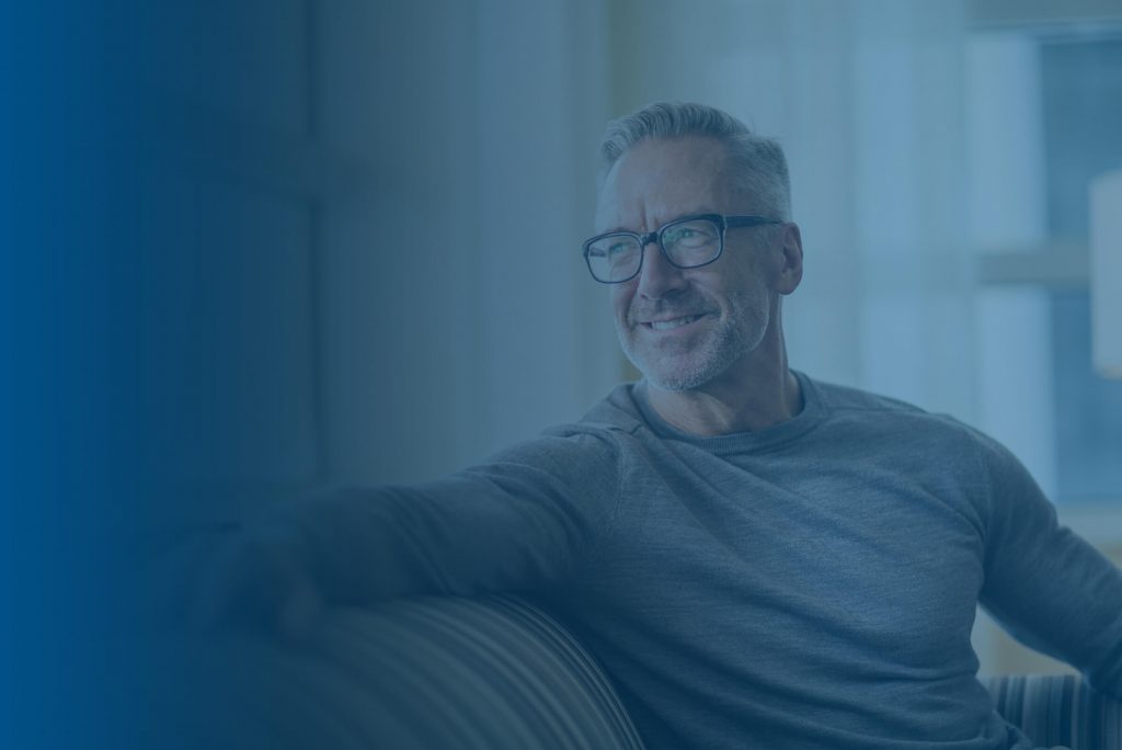 Older Man sitting on chair looking happy and confident